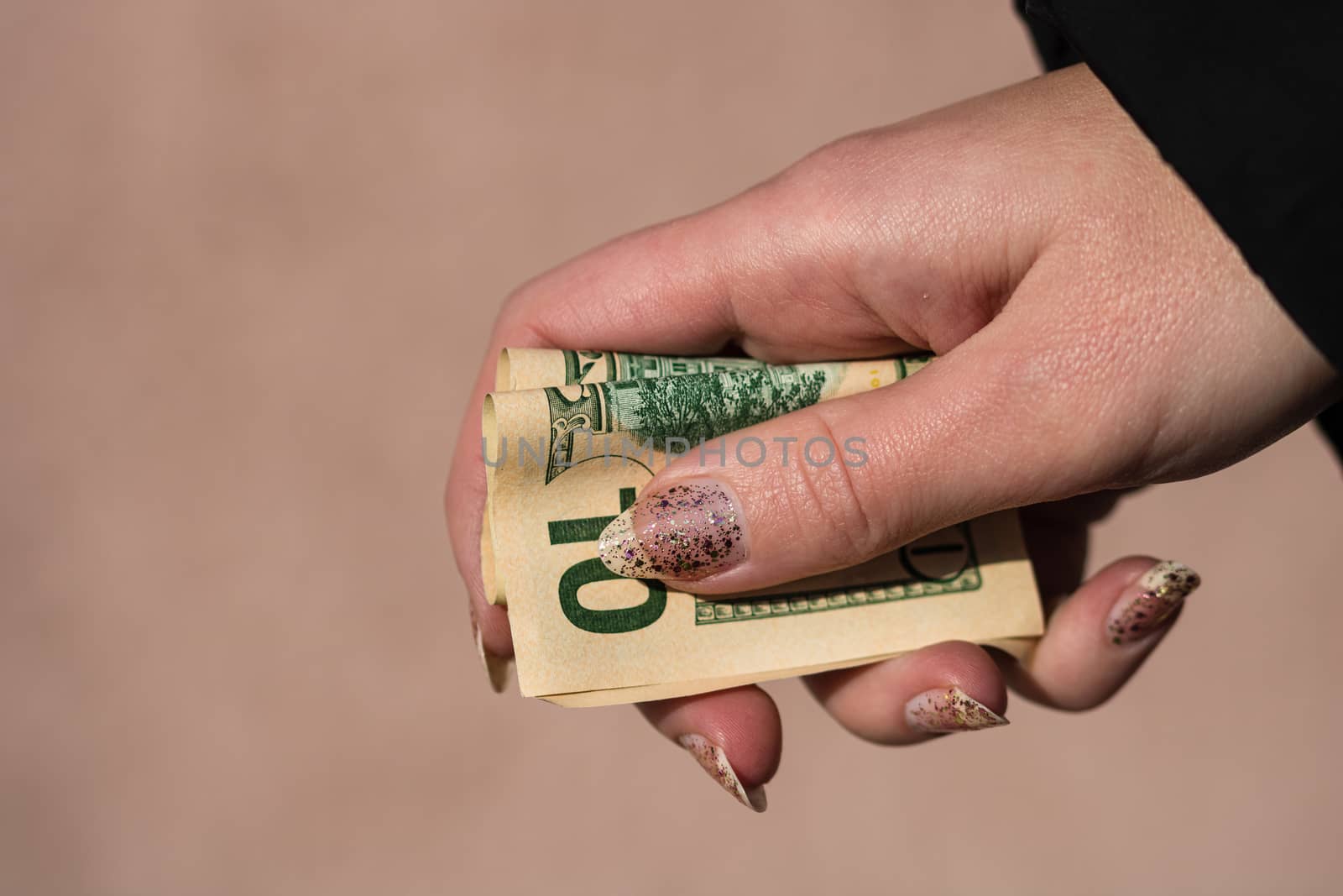 Hands giving money like a bribe or tips. Holding US dollars banknotes on a blurred background, US currency