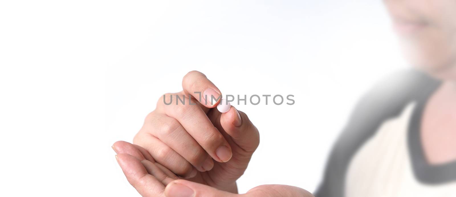 People taking or holding a white medicine pill in hand  by gnepphoto