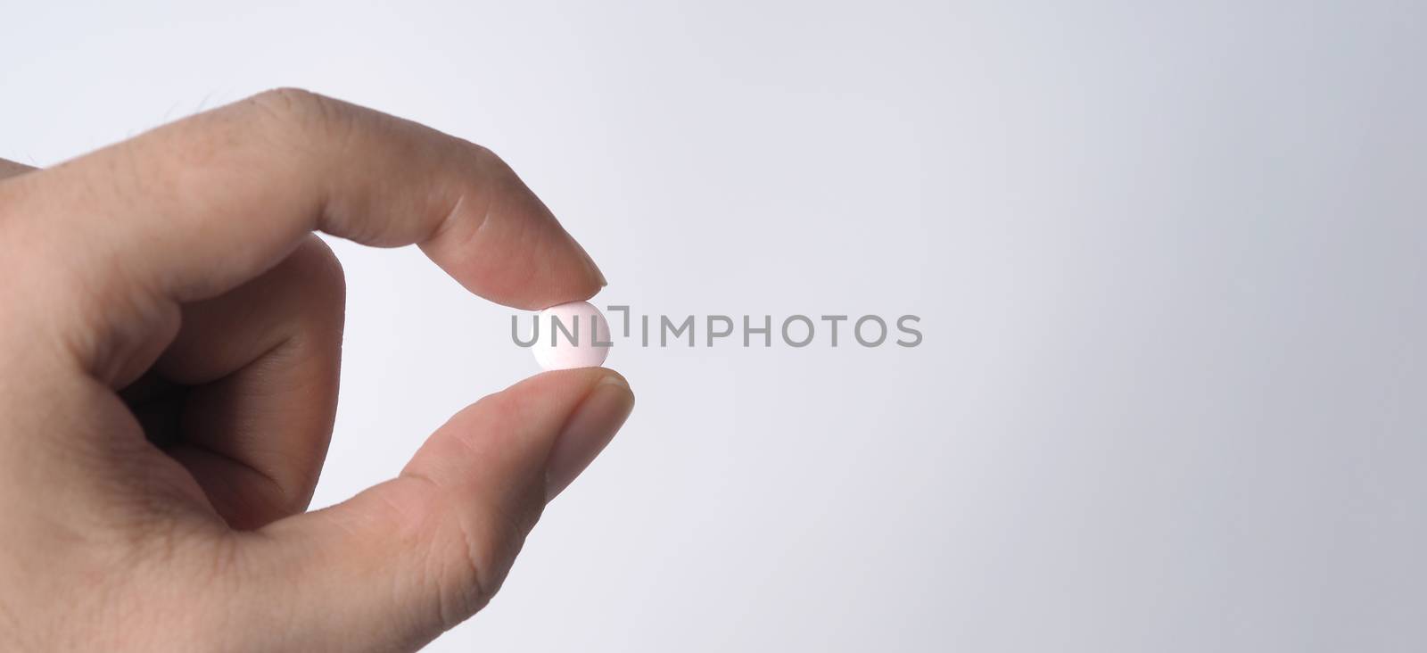 People taking or holding a white medicine pill in hand which help and protect from pandemic virus and relief them from unhealthy and sickness. studio close up shot and clear background.
