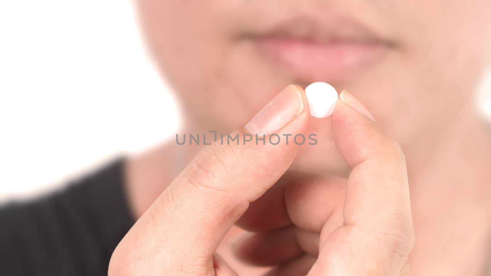 People taking or holding a white medicine pill in hand  by gnepphoto
