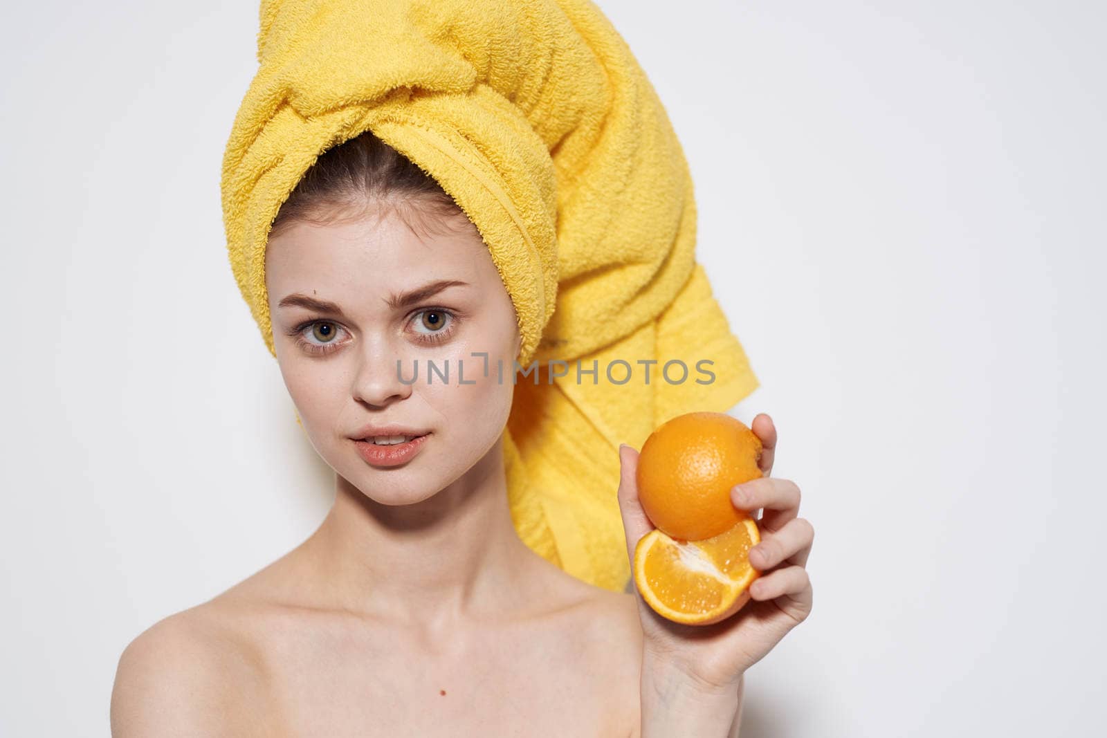 Cheerful woman with bared shoulders oranges in the hands of citrus skin care vitamins health by SHOTPRIME