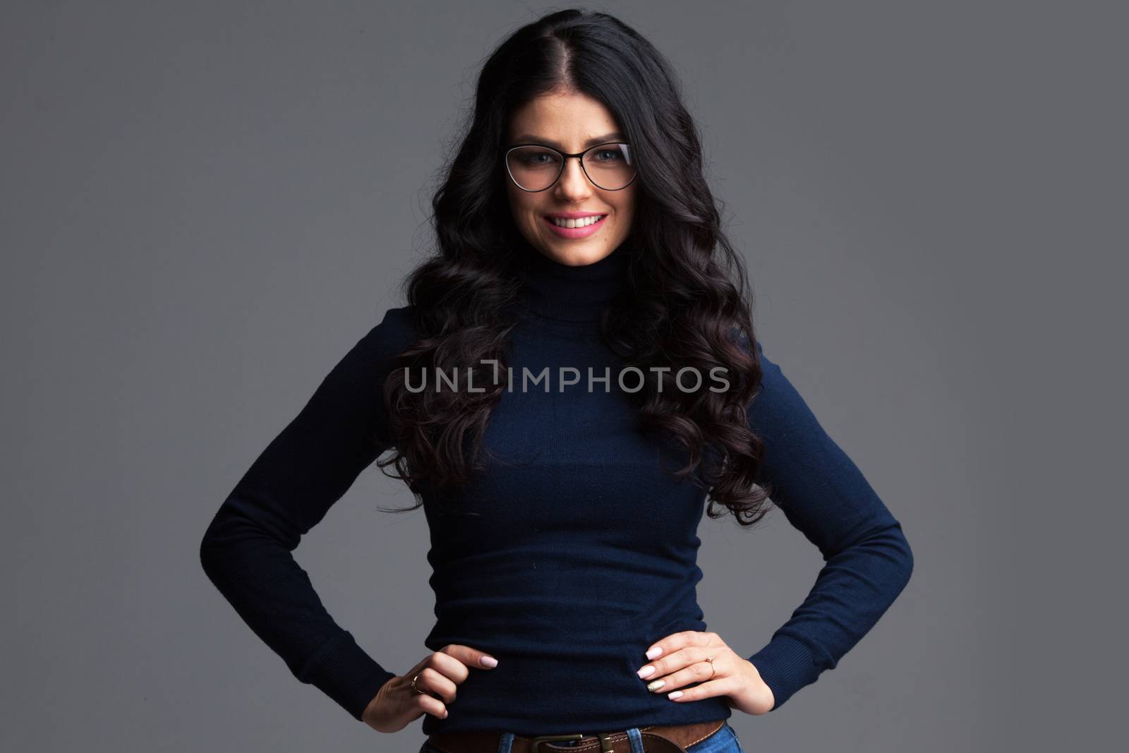 Portrait of beautiful brunette woman in glasses over gray background