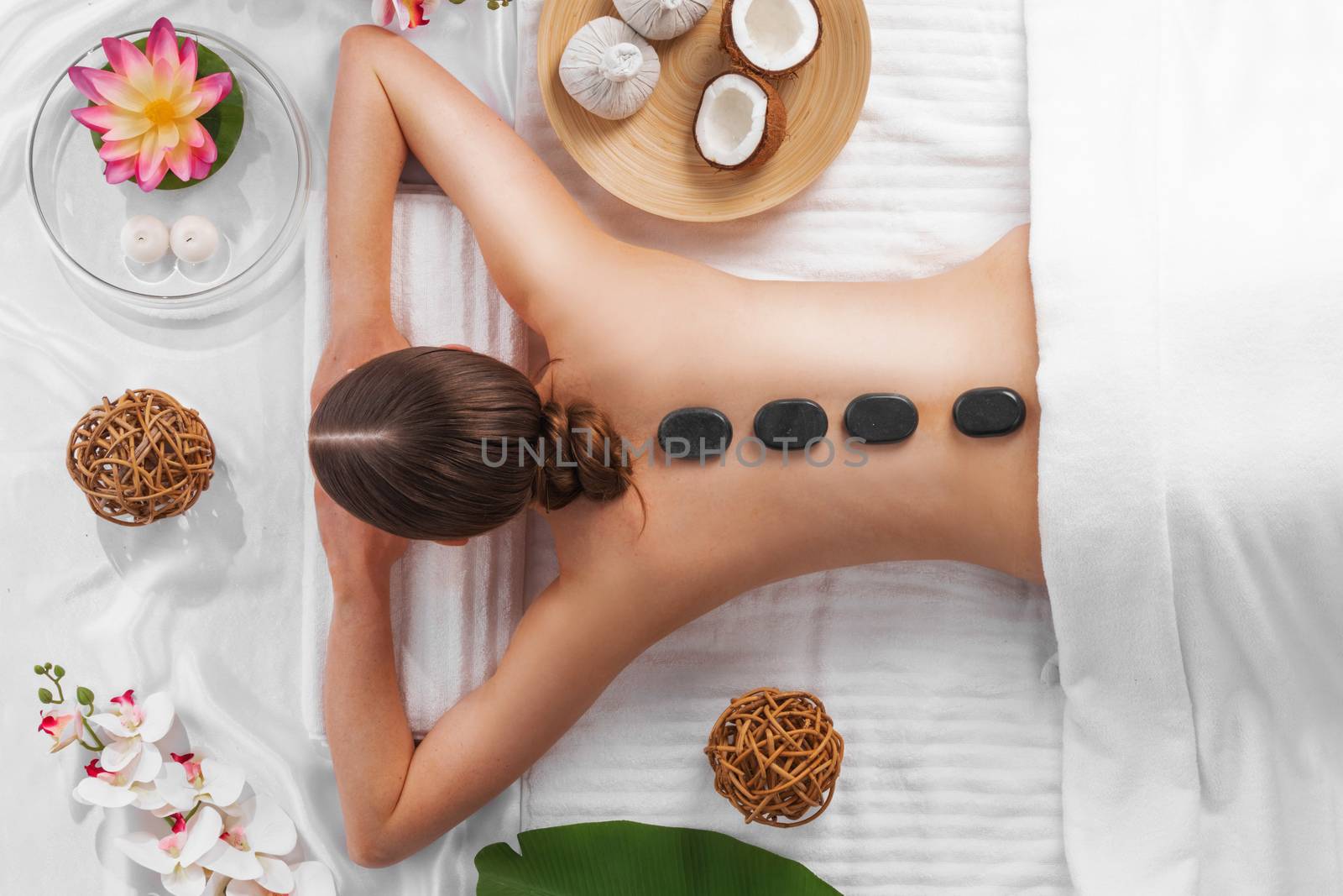 Woman getting spa hot stones massage by ALotOfPeople