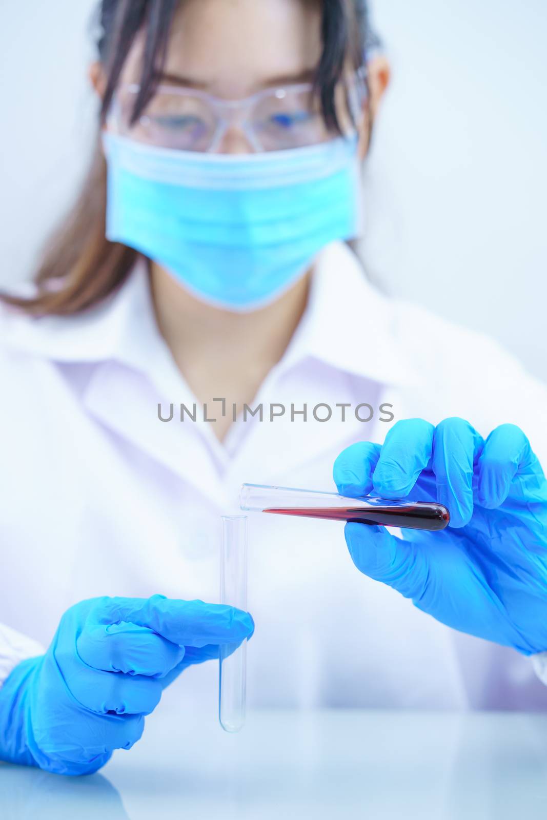 Technician scientist analyzing a blood sample in test tube in laboratory for testing it on COVID, COVID-19, coronavirus virus analysis