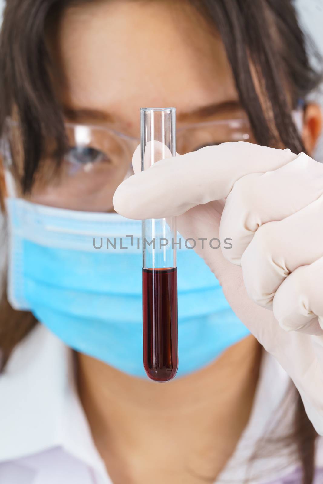 Scientist analyzing holding blood sample in test tube by stoonn