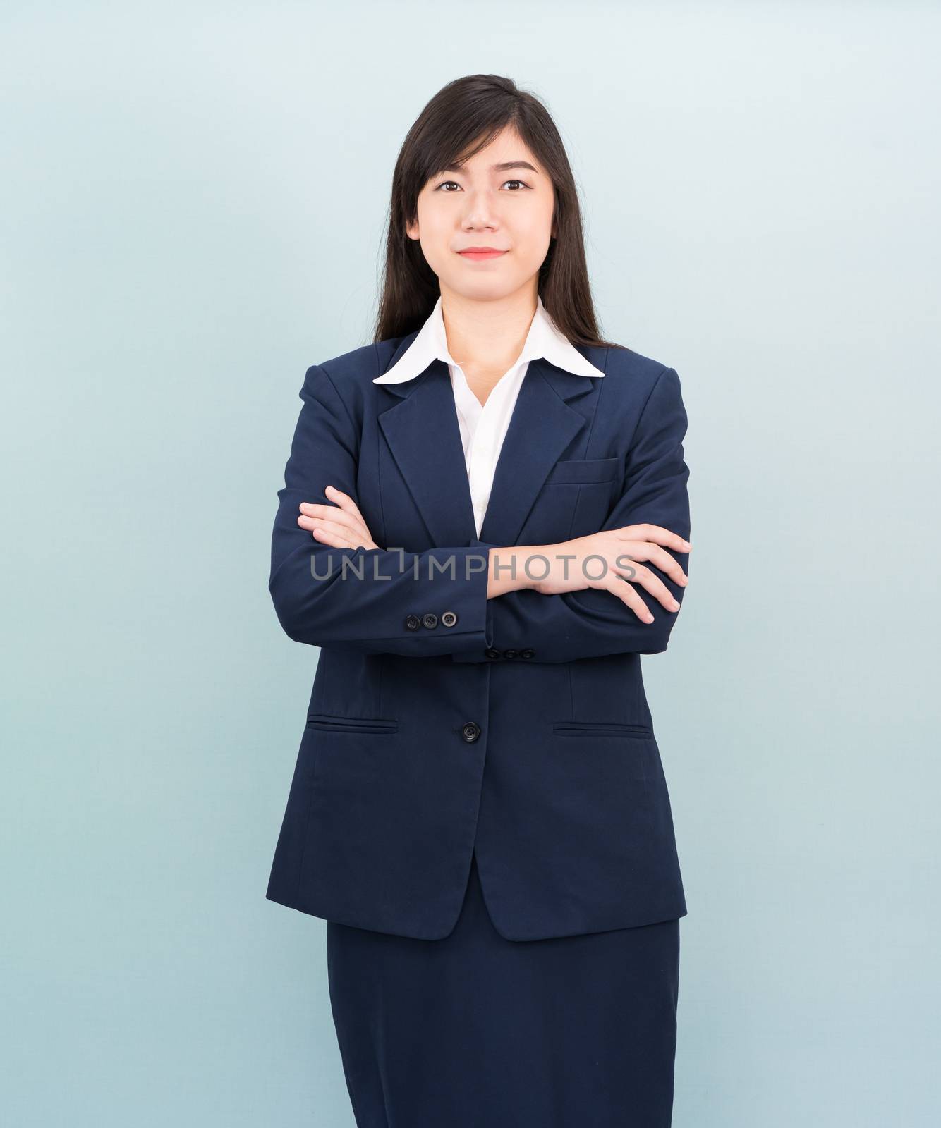 Teenage girl long hair is standing with her arms crossed by stoonn