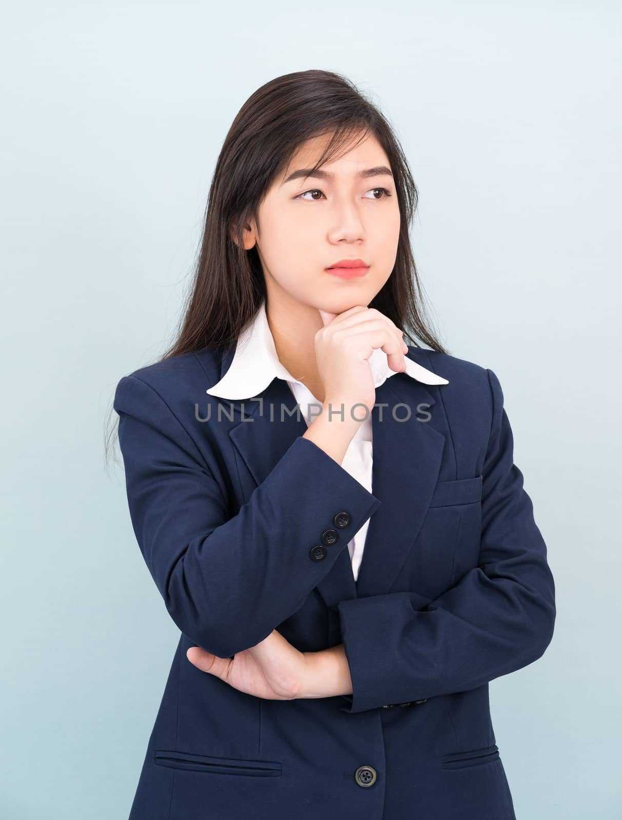 Teenage young girl wearing suit with hand on chin isolated on blue background