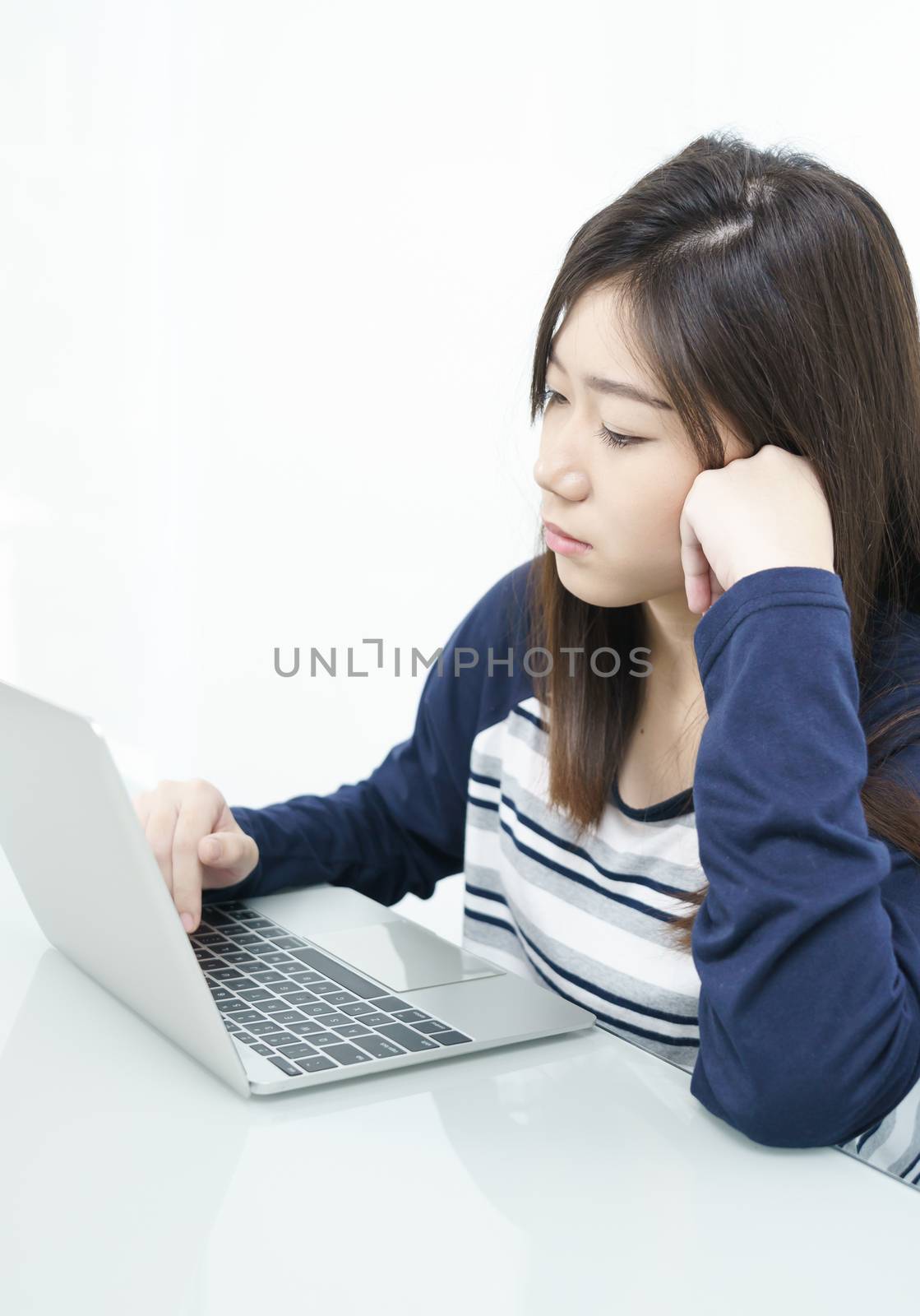 Young female student  sitting in living room and learning online by stoonn