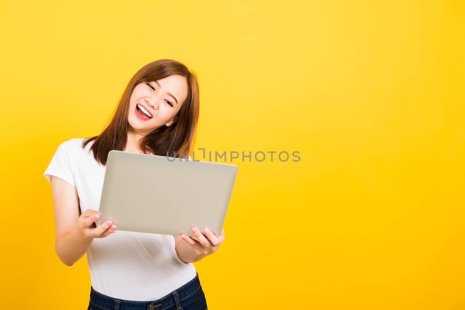 woman teen smile standing wear t-shirt hold laptop computer and  by Sorapop
