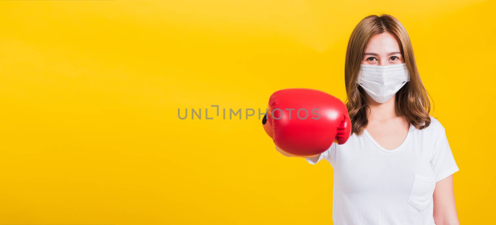 woman wearing mask protection and boxing gloves by Sorapop