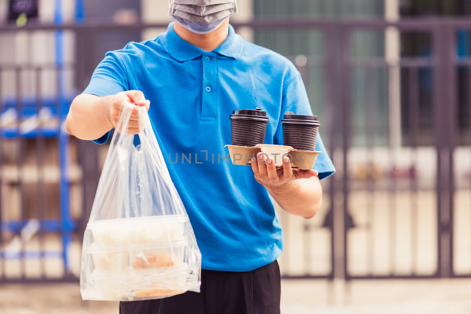 Delivery man wearing face mask making grocery giving rice food b by Sorapop