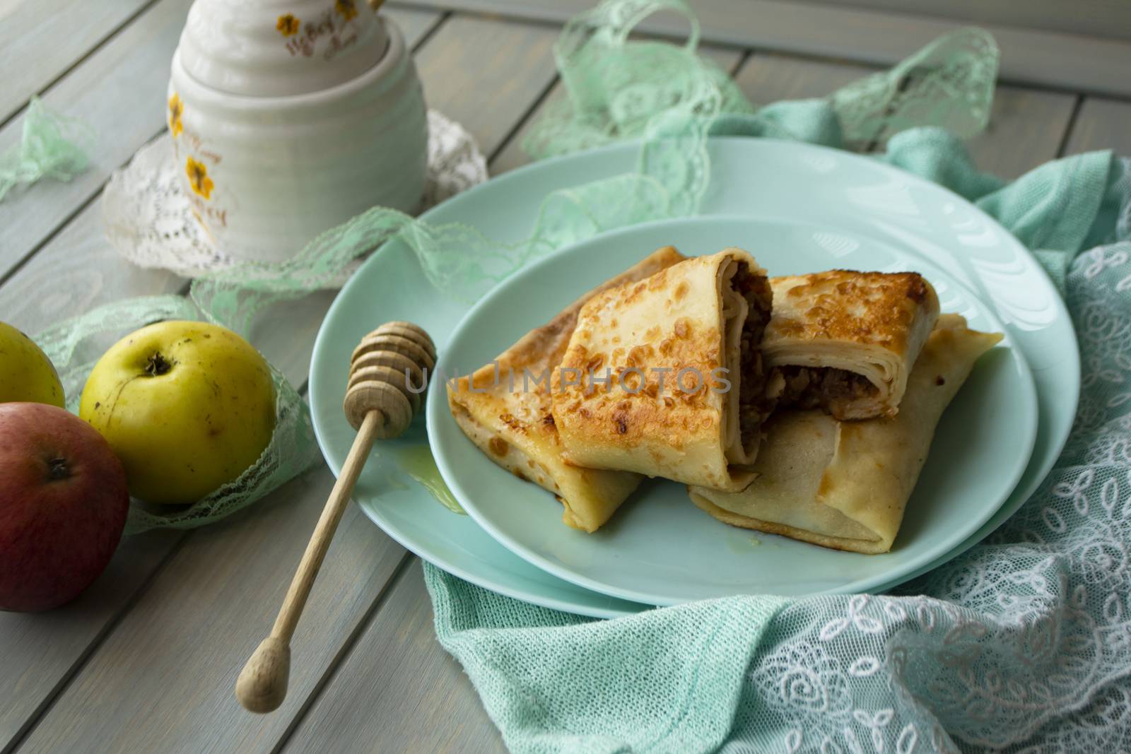 Apple cinnamon crepes. Pancakes with caramelized apples and cinnamon. Teal background
