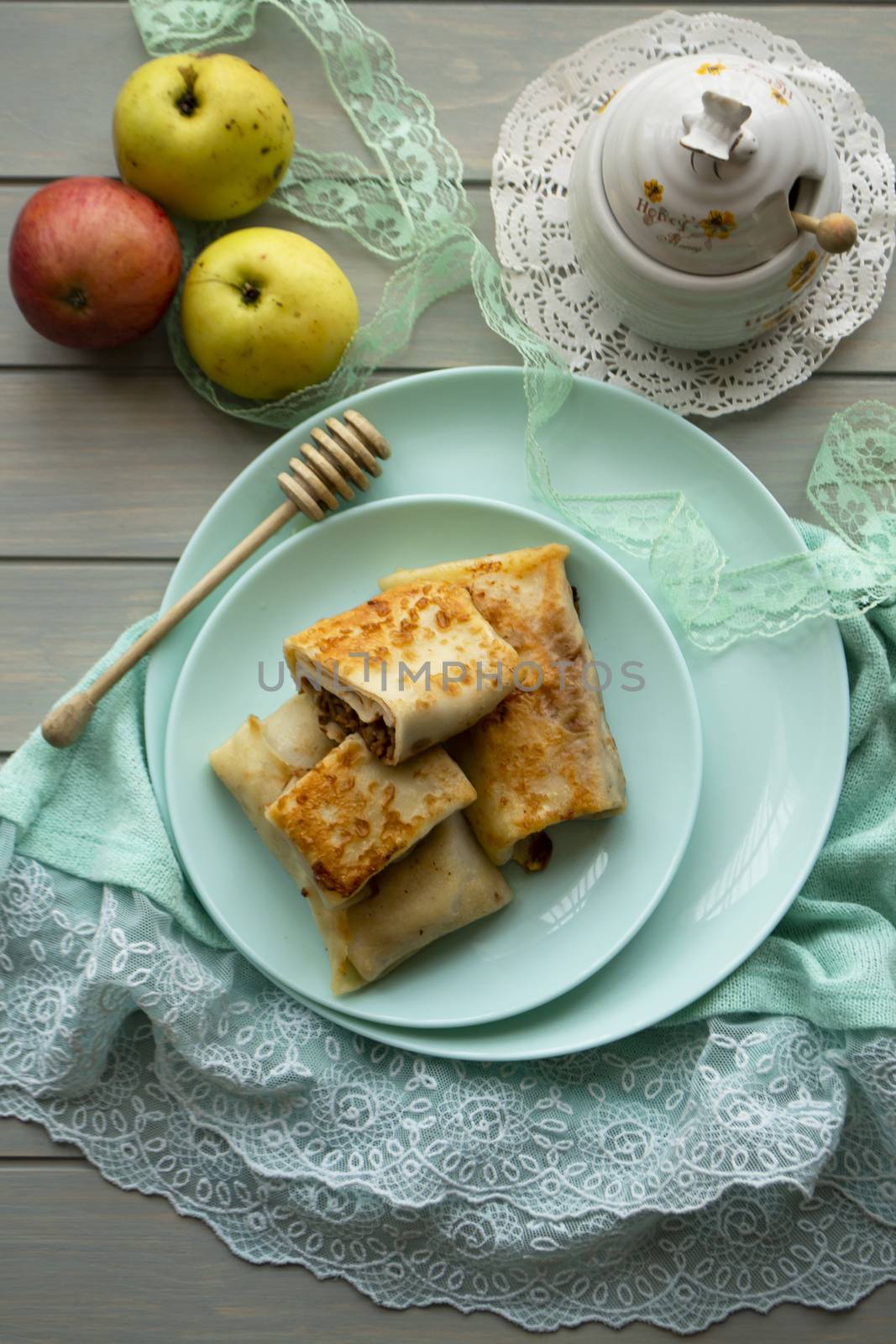 Pancake rolls with apple and honey, vertical image