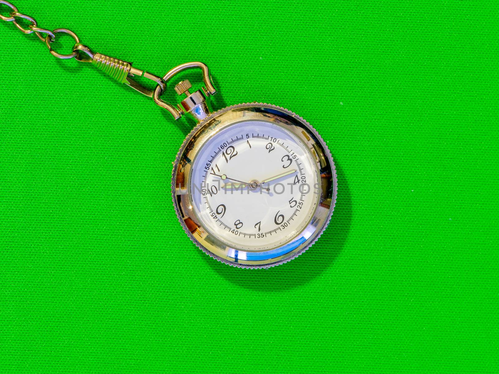 Small steel pocket watch with white dial, metal object on a uniform colored background