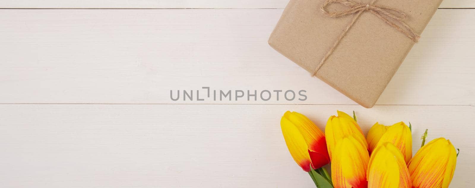 Beautiful tulip flower and gift box on wooden background with romantic, presents for mother day with pastel tone, spring or summer nature for decoration on desk, holiday concept, banner website. by nnudoo