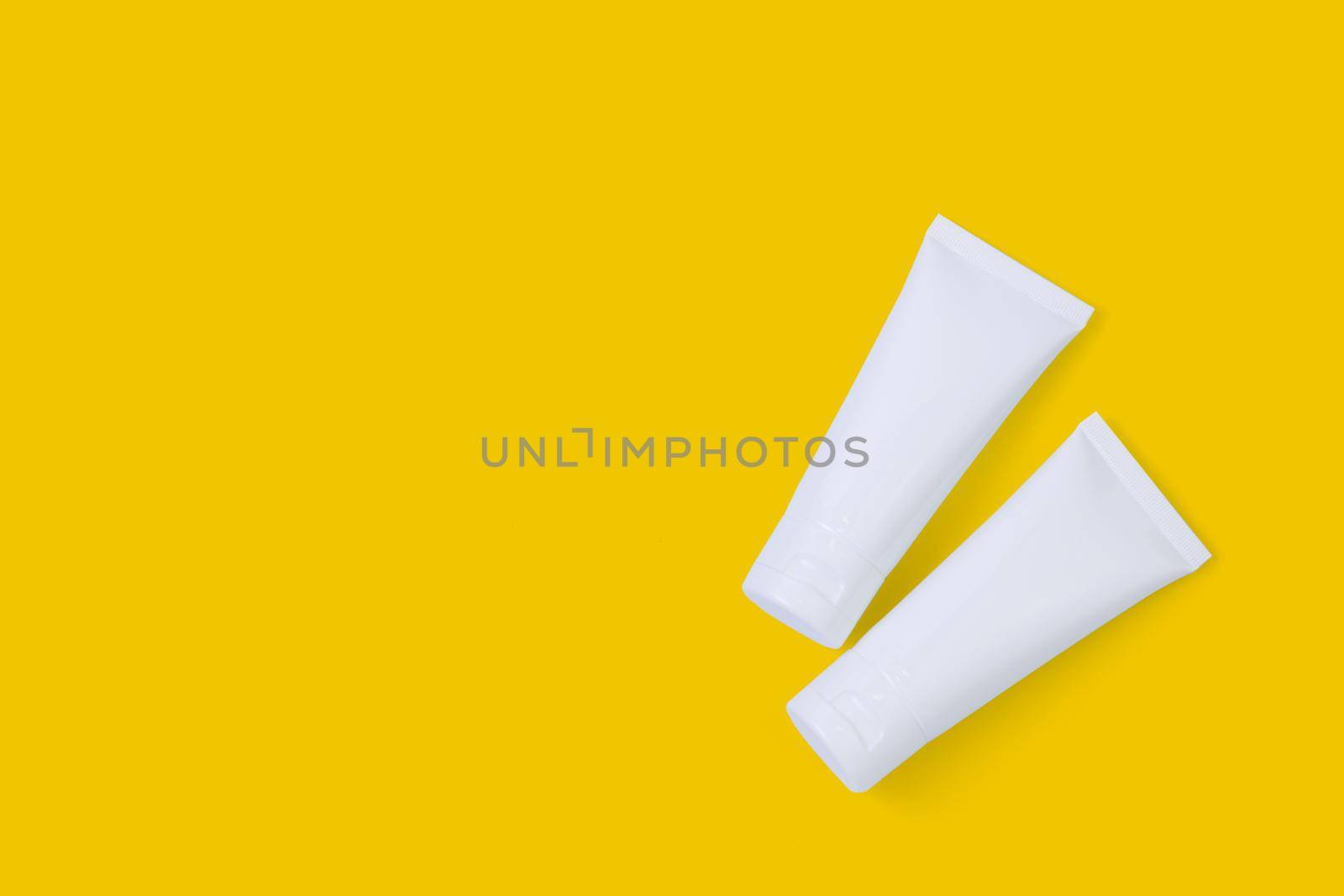 Cosmetic tube isolated on yellow background, mockup package of lotion or cream, product beauty and makeup, treatment skin care or acne, packaging or container, health and medicine template.