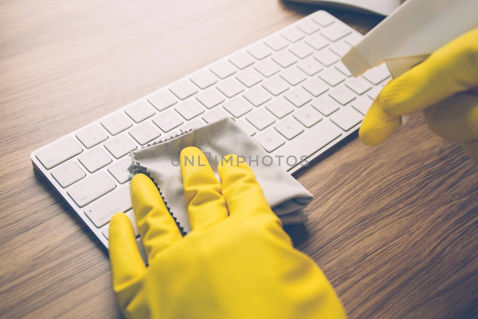 Hand of man cleaning keyboard computer with antibacterial for protect epidemic disease covid-19, fabric having antiseptic alcohol clean and wash laptop for on desk, business and health concept.