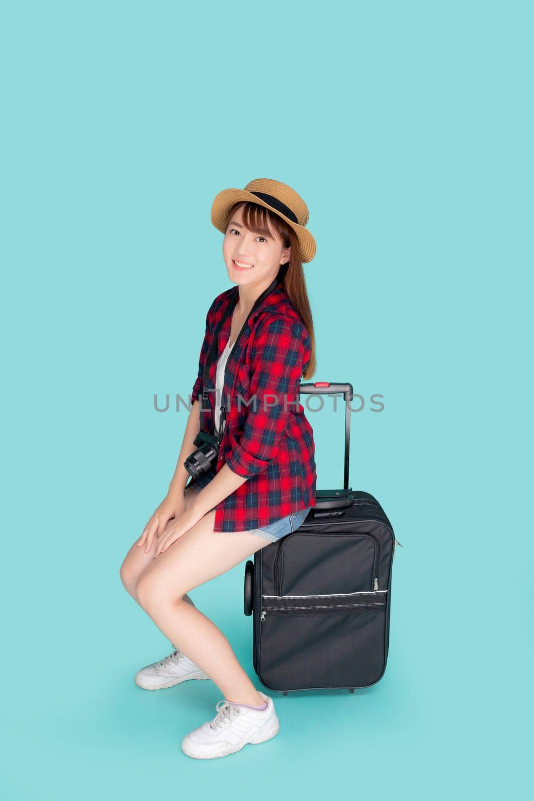 Beautiful portrait young asian woman sitting on luggage smiling and travel summer trip for abroad in vacation, happy asia girl having camera sitting on suitcase for journey with cheerful in holiday. by nnudoo