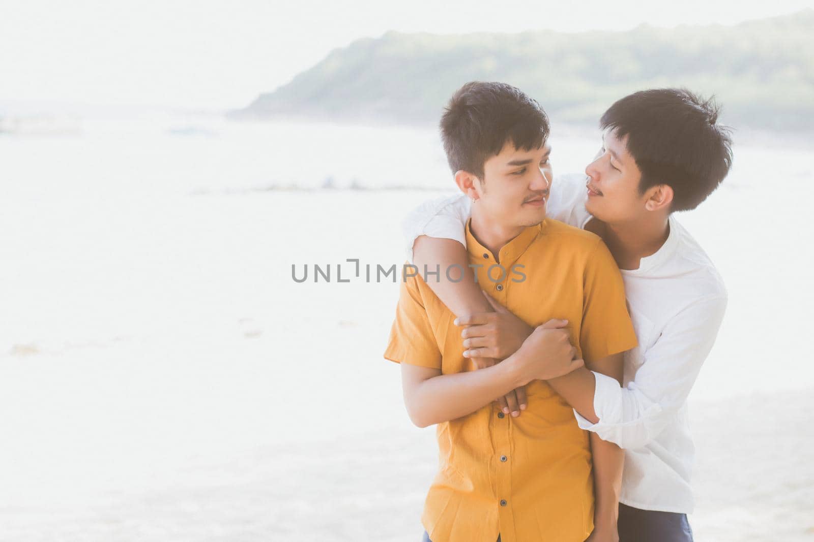 Homosexual portrait young asian couple standing hug together on beach in summer, asia gay going tourism for leisure and relax with romantic and happiness in vacation at sea, LGBT concept. by nnudoo