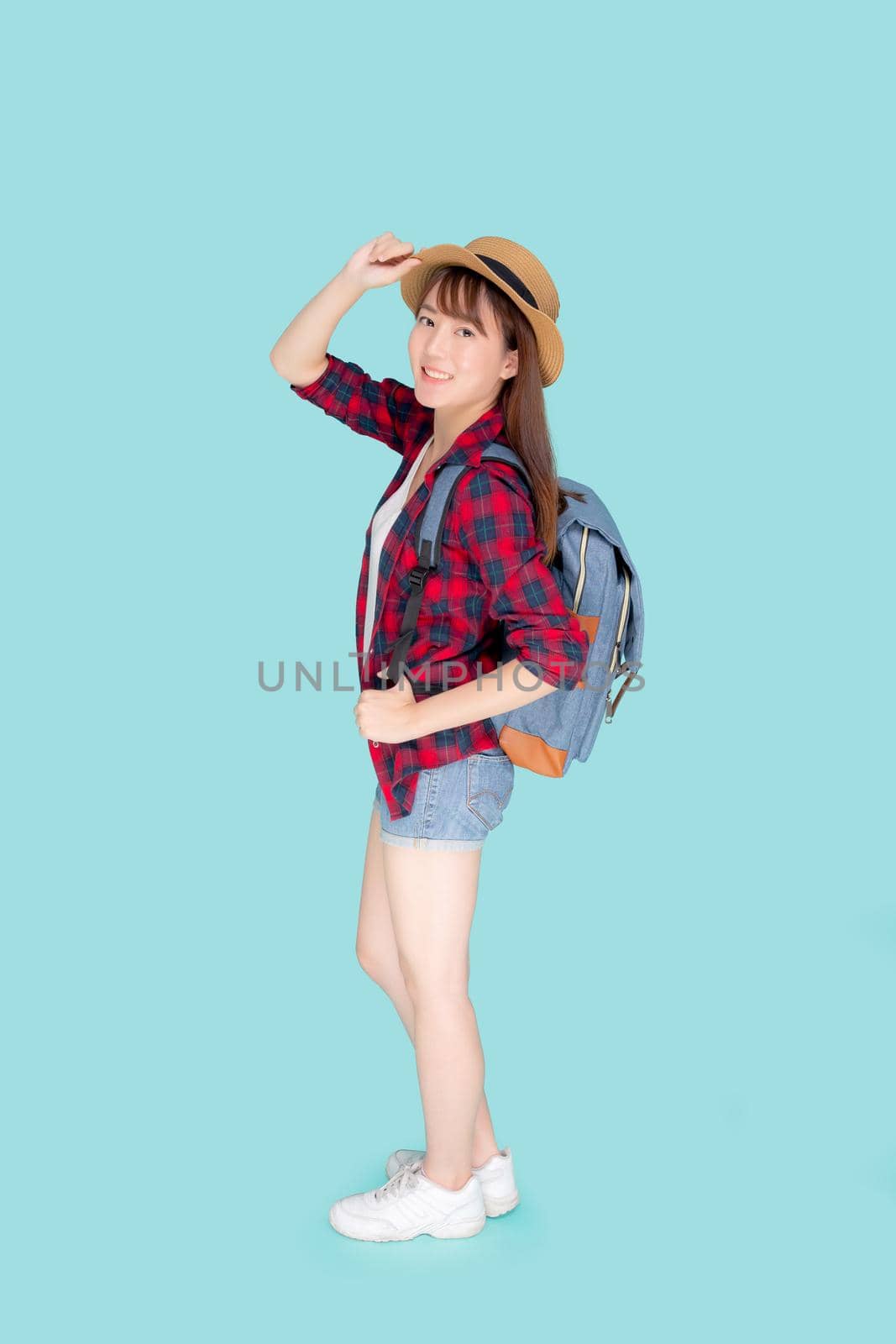 Beautiful portrait young asian woman holding hat smile expression cheerful and enjoy travel summer trip holiday in vacation isolated blue background, tourist happy asia girl confident and excited. by nnudoo