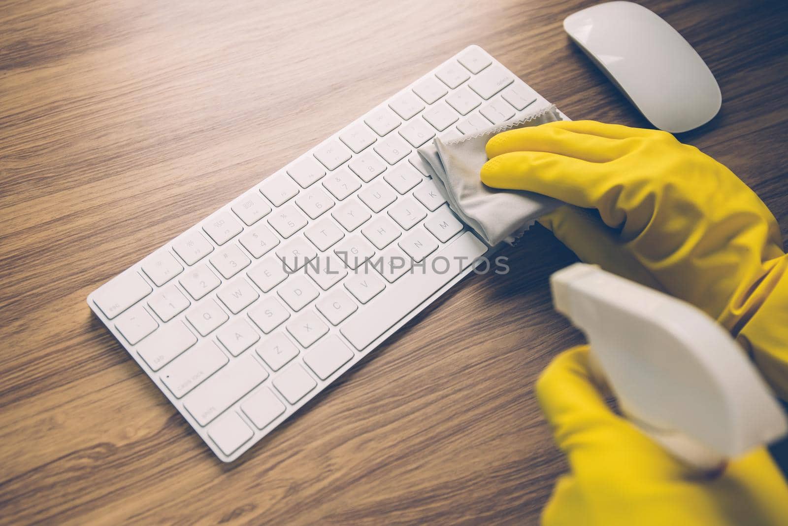 Hand of man cleaning keyboard computer with antibacterial for protect epidemic disease covid-19, fabric having antiseptic alcohol clean and wash laptop for on desk, business and health concept.