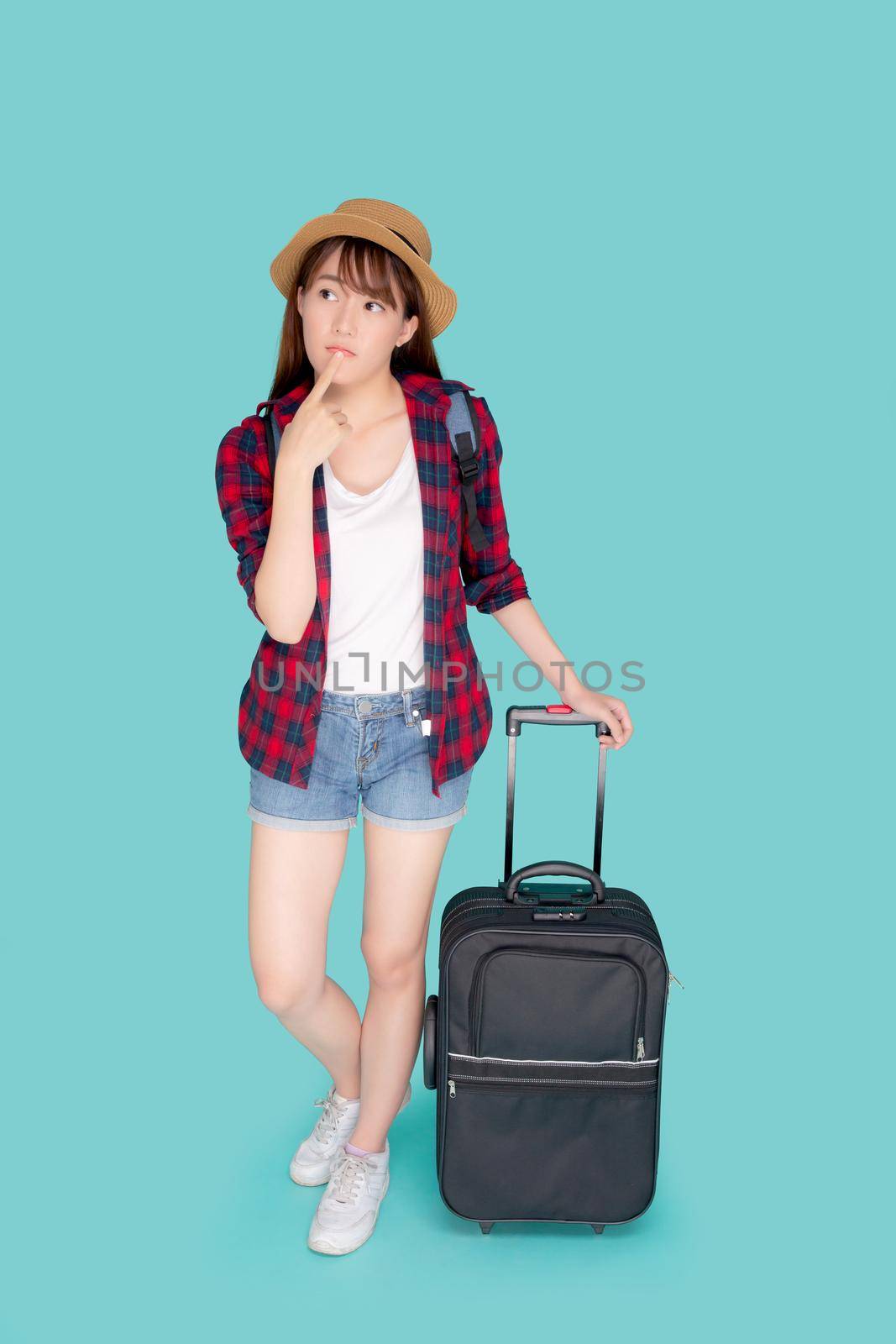 Beautiful portrait young asian woman thinking idea travel in vacation with luggage isolated on blue background, asia girl journey expression with cheerful and happy, holiday in summer concept.