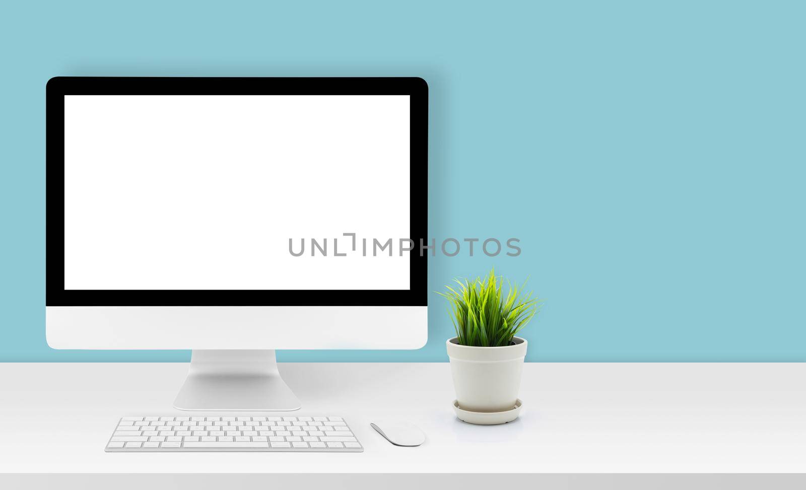 Mockup desktop computer display blank screen on desk in office, workspace with mock up computer screen empty and keyboard, mouse, plant and copy space on table in home, business presentation concept.