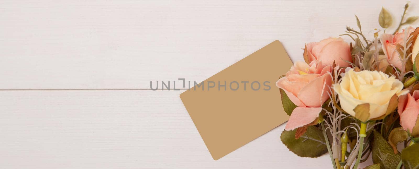 Beautiful flower and tag on wooden background with romantic, mother day or valentine day with pastel tone, nature background for decoration, floral for gift on desk, holiday concept, banner website. by nnudoo