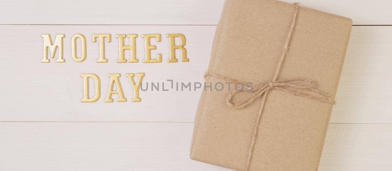 Gift box and text is mother day on wooden background with romantic, presents word and message, package with congratulation with happy, nature on desk, holiday concept, banner website.