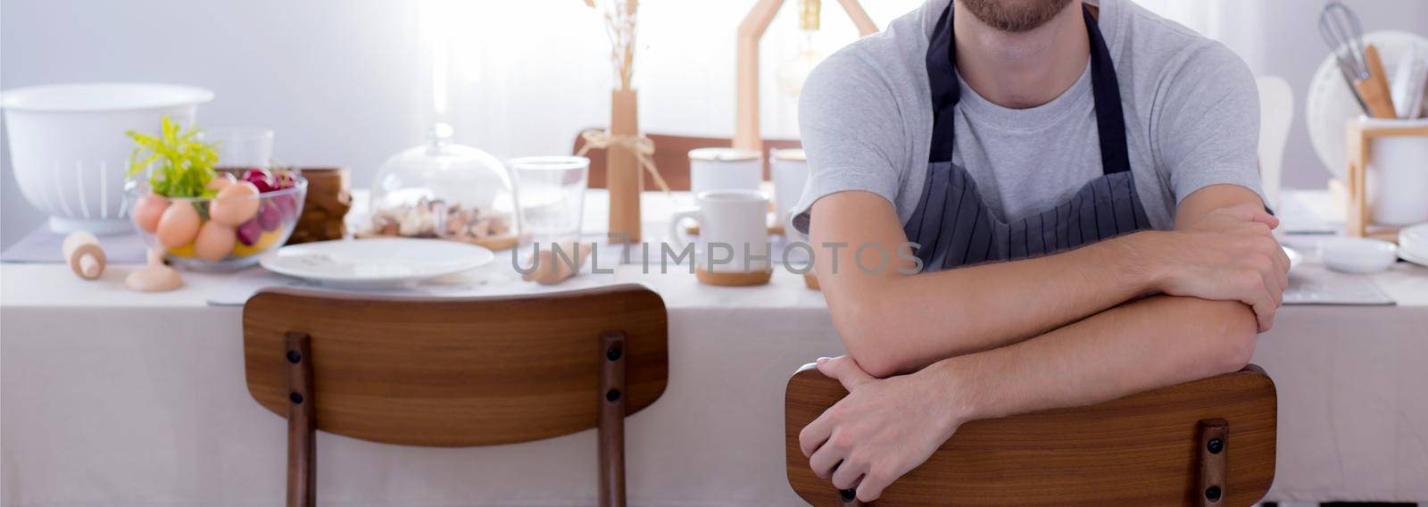 Happy young man wearing apron preparing to cook in kitchen at home, chef with culinary, restaurant and proud, domestic life, portrait of male cheerful and happy cooking food, lifestyle concept. by nnudoo