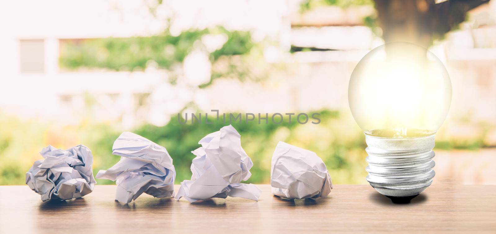 Idea and inspiration concept with paper crumple and light bulb about success, creative and imagination of team with metaphor, solving problem; genius and clever, achievement of result, banner website. by nnudoo