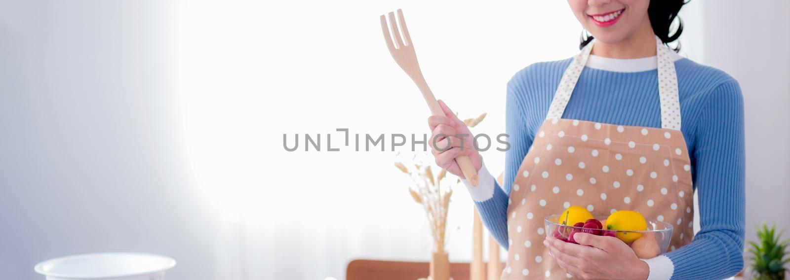 Happy young asian woman wearing apron preparing to cook in kitchen at home, chef with culinary, restaurant and proud, domestic life, portrait girl cheerful and happy cooking food, lifestyle concept. by nnudoo