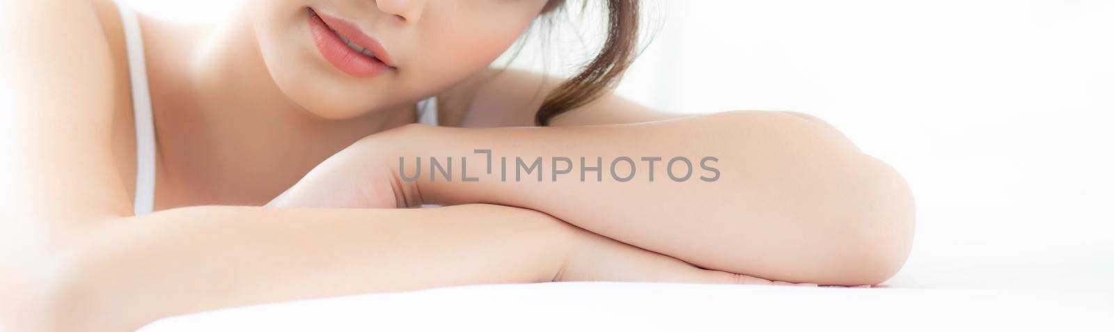 Portrait beautiful young asian woman smile while wake up healthy and wellness at morning on bed, beauty asia girl happy lying skin care and makeup cosmetic at bedroom, lifestyle and relax concept.