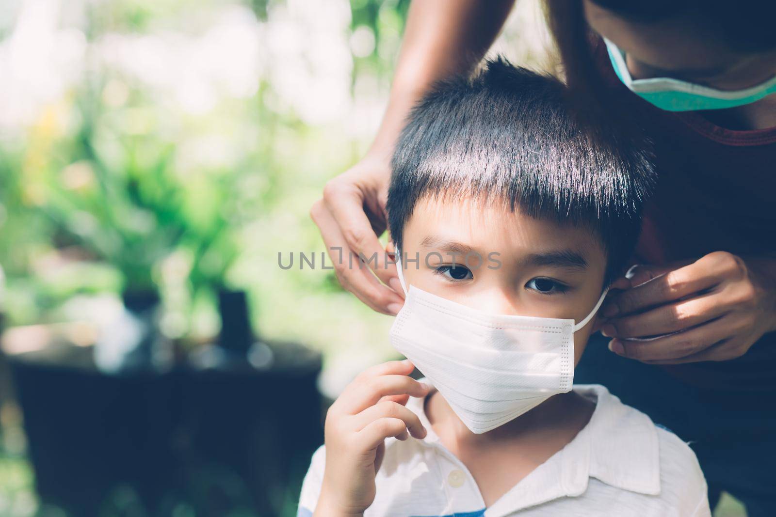 Mother take care son with face mask for protection disease flu or covid-19 outdoors, mom wearing on medical mask with child safety for protect outbreak of pandemic in public, medical concept.