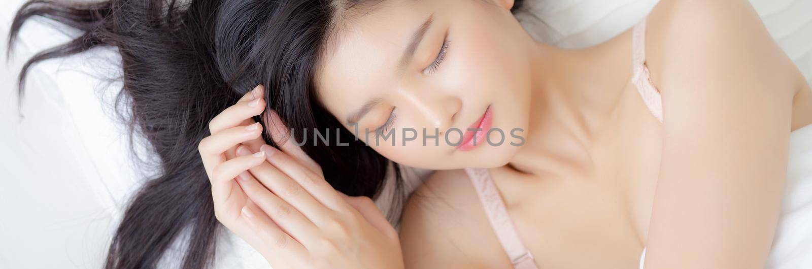 Beautiful asian young woman in underwear sleep lying on bed with comfort and happy leisure at bedroom, beauty asia girl relax with cozy for health at home, lifestyle concept, banner website. by nnudoo