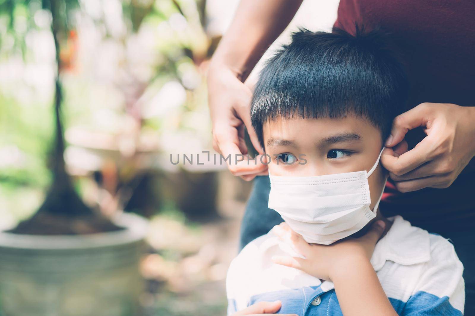 Mother take care son with face mask for protection disease flu or covid-19 outdoors, mom wearing on medical mask with child safety for protect outbreak of pandemic in public, medical concept.