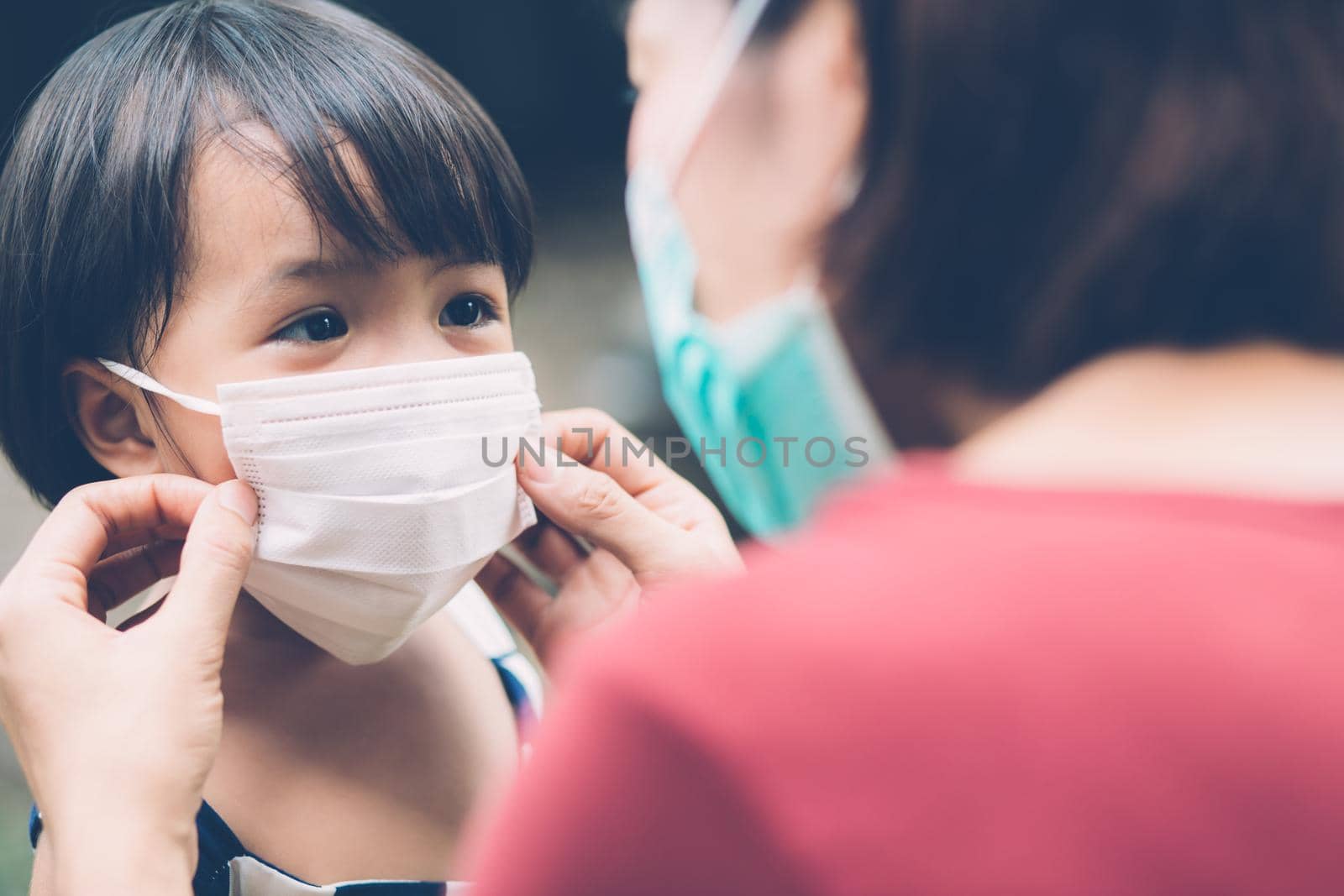 Mother take care daughter with face mask for protection disease flu or covid-19 outdoors, mom wearing on medical mask with child safety for protect outbreak of pandemic, medical concept.