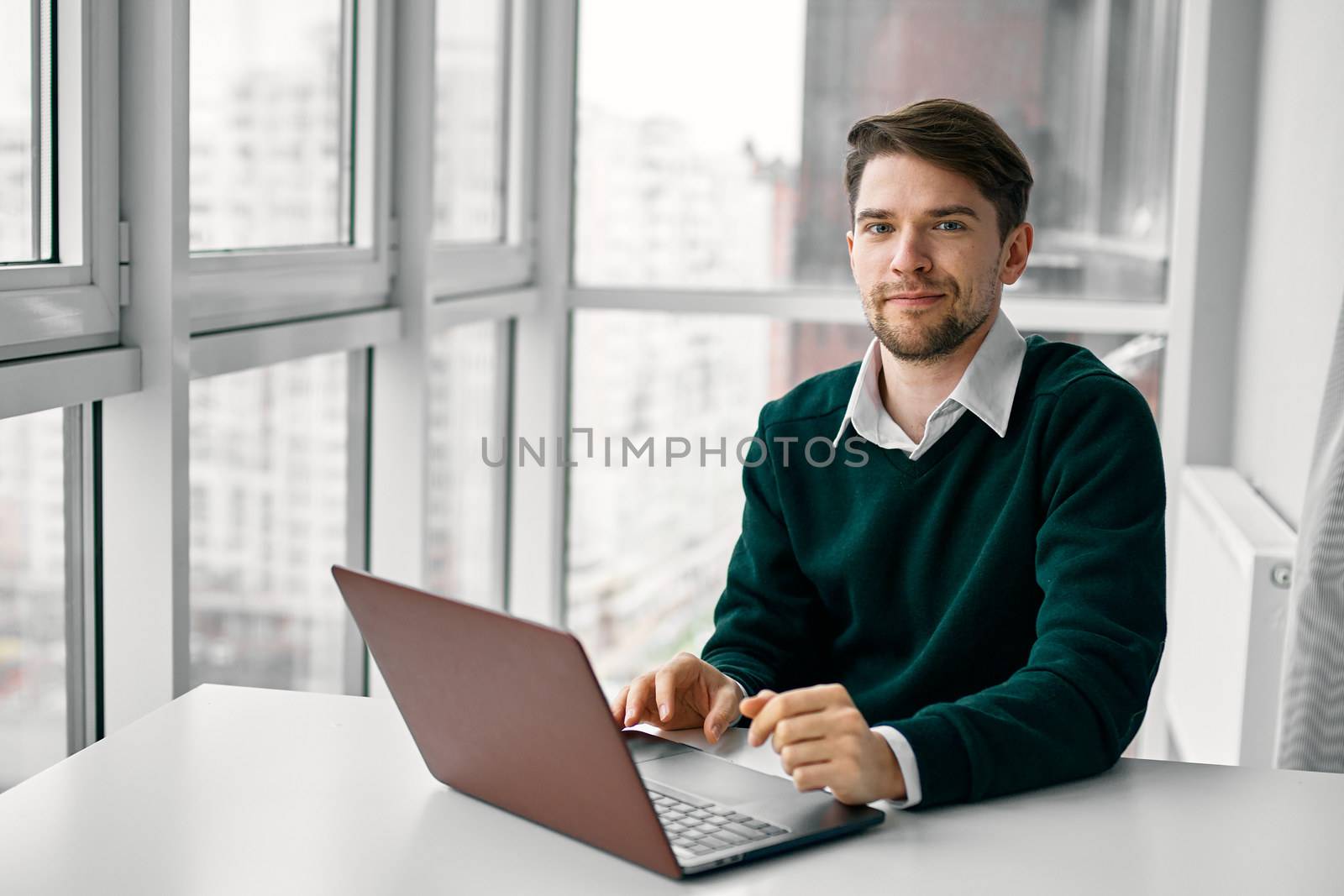 A man at a table in front of a laptop professional job internet by SHOTPRIME