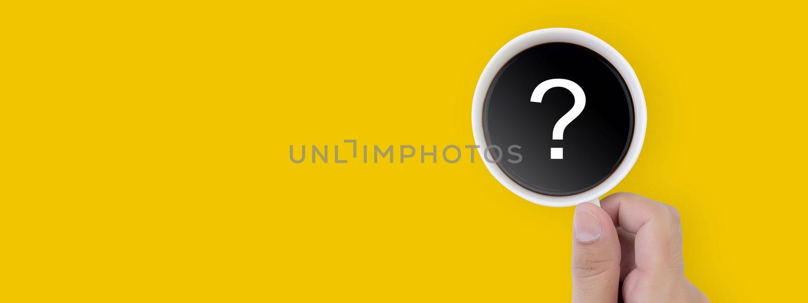Hand holding cup of hot coffee with question mark isolated on yellow background, top view, q & a, faq or assistance for incentive, beverage, communication and idea concept, banner website.