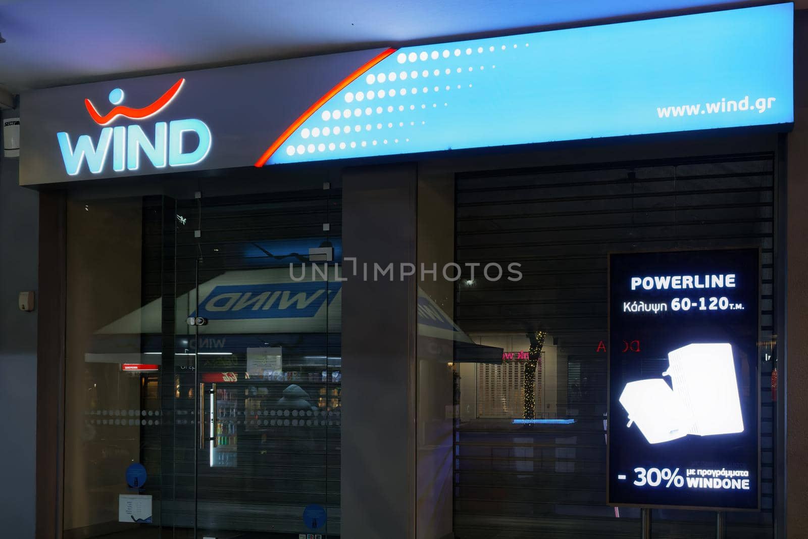 Illuminated night view of closed store entrance of Hellenic mobile operator.