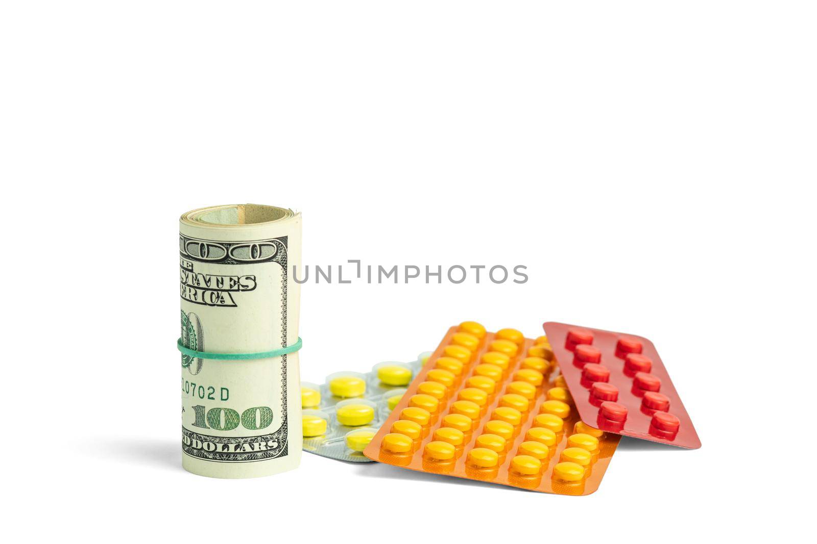 Rolled up banknotes next to medications. Treatment cost. Medical business. Pharmaceutical business. Objects isolated on white with shadow.