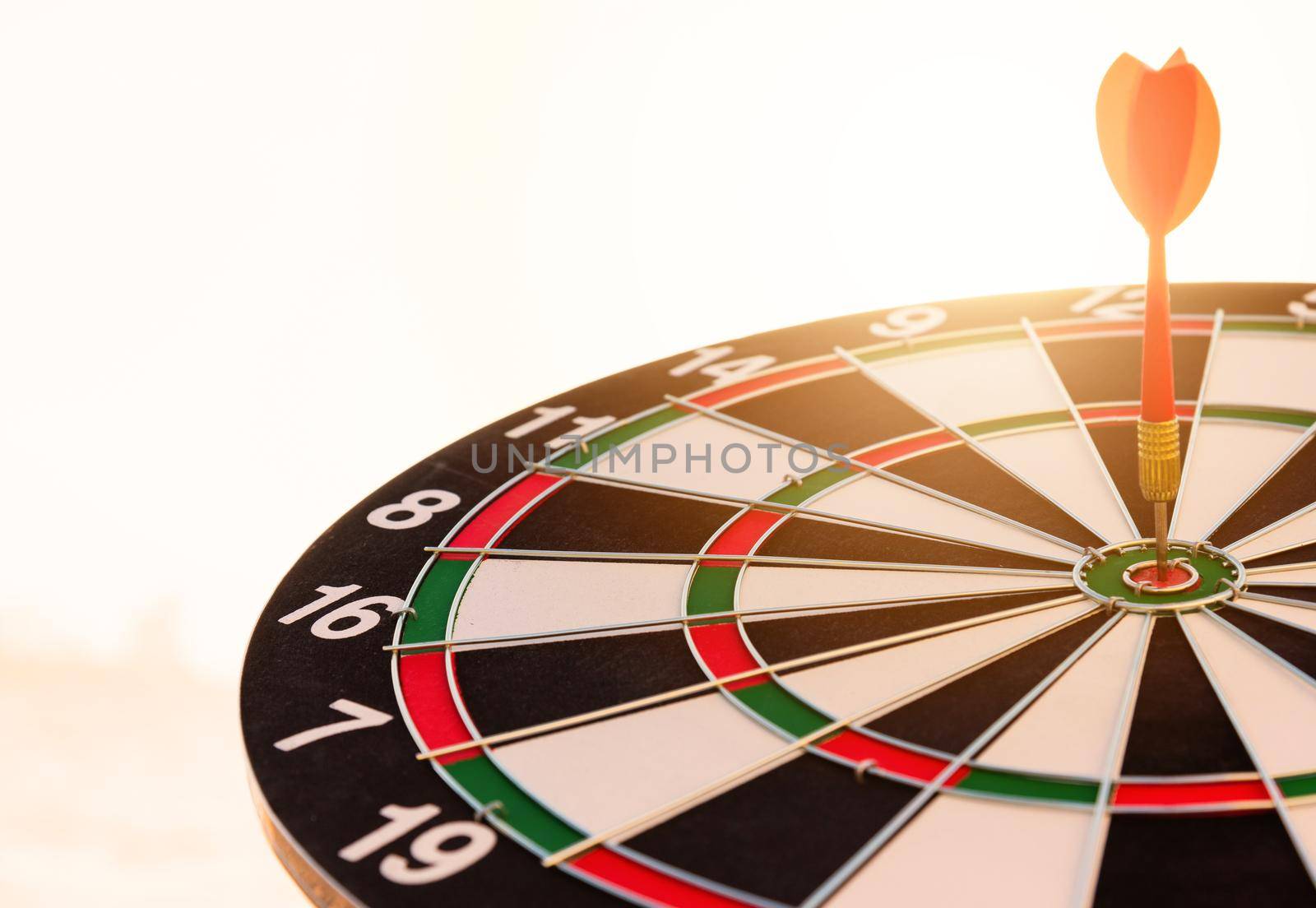 Dart arrow hit to center on bullseye of a dartboard by Sorapop