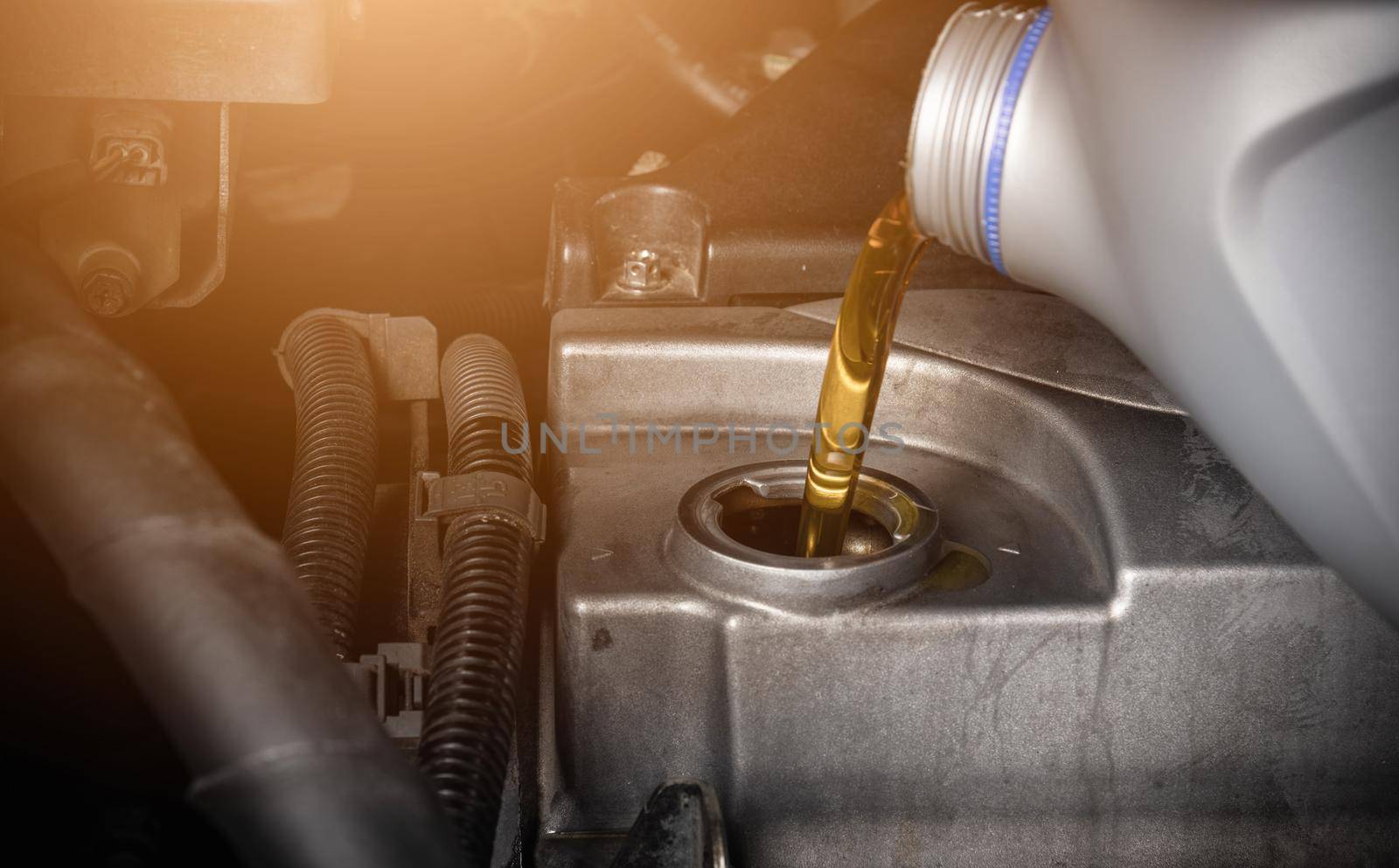 Hand mechanic in service to repair a car, pouring change lubricant oil