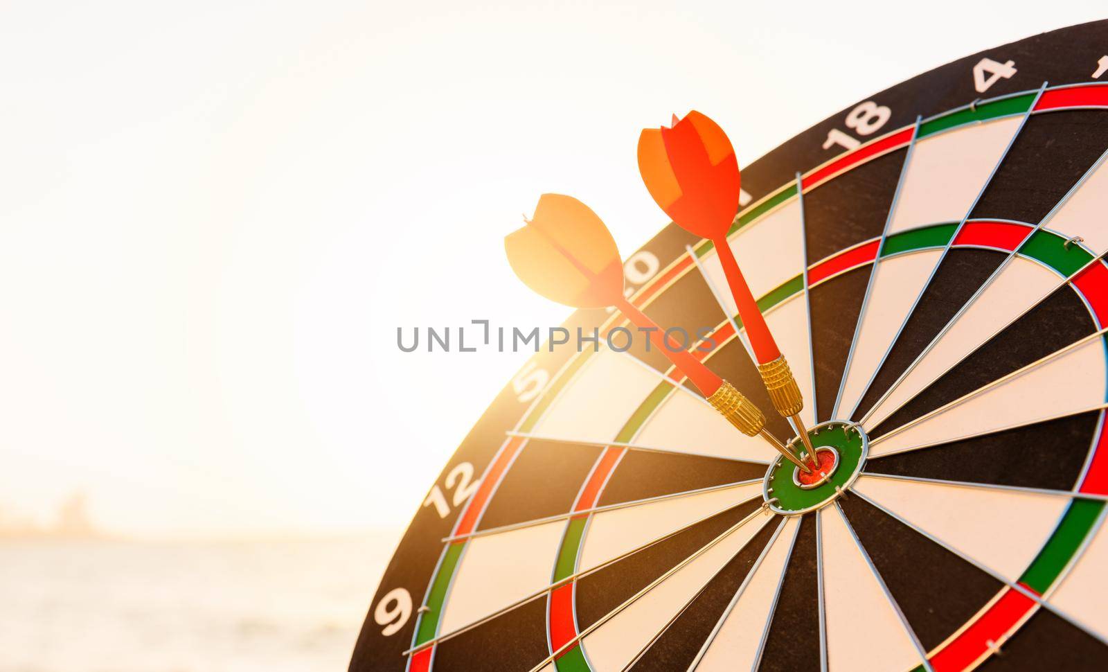Dart arrow hit center on bullseye dartboard is target by Sorapop