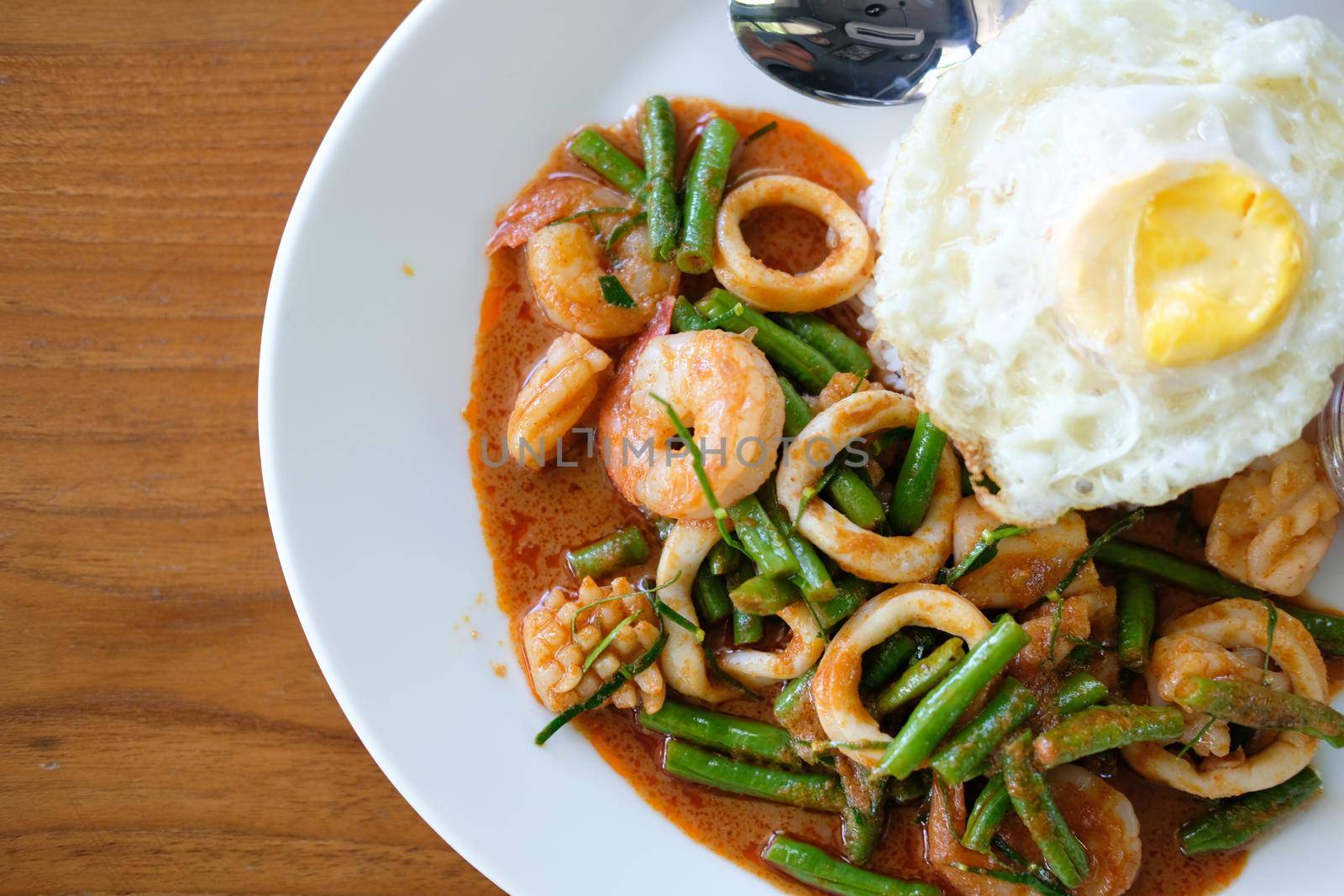 shrimp squid stir fried with cow pea & spicy sauce serving with rice & fried egg