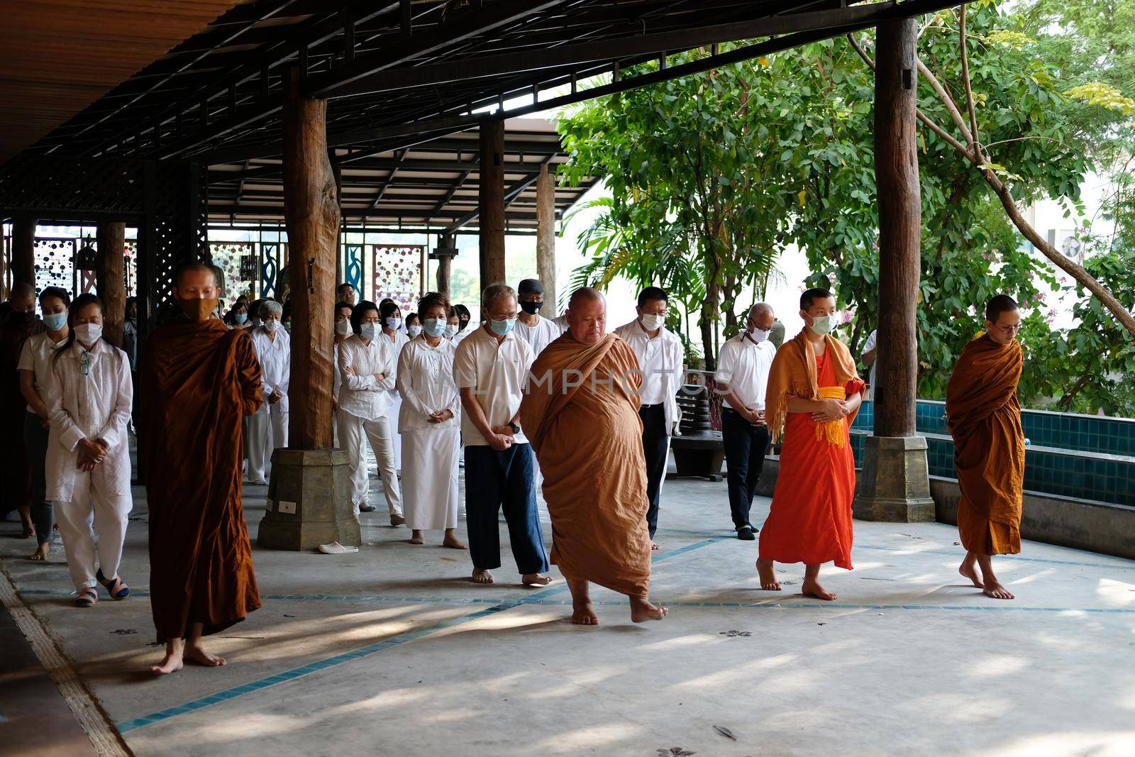 Chiang Mai, Thailand -  November 18, 2020: buddhist monk and people walking for mindfulness meditation at Khumphucome hotel in Chiang Mai, Thailand on November 18, 2020