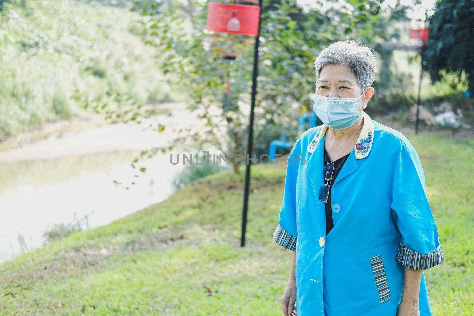 asian old elderly elder woman wearing facial mask resting relaxing in garden. senior leisure lifestyle