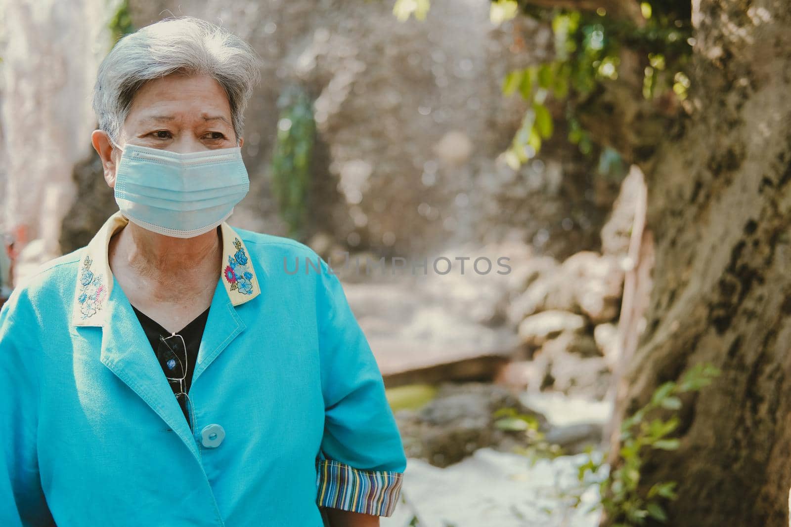 asian old elderly elder woman wearing facial mask resting relaxing in garden. senior leisure lifestyle