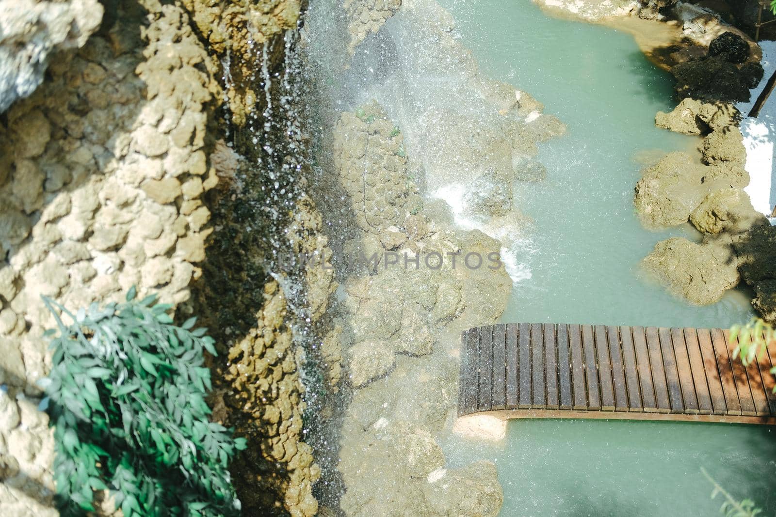 bridge and manmade waterfall park. flowing water stream