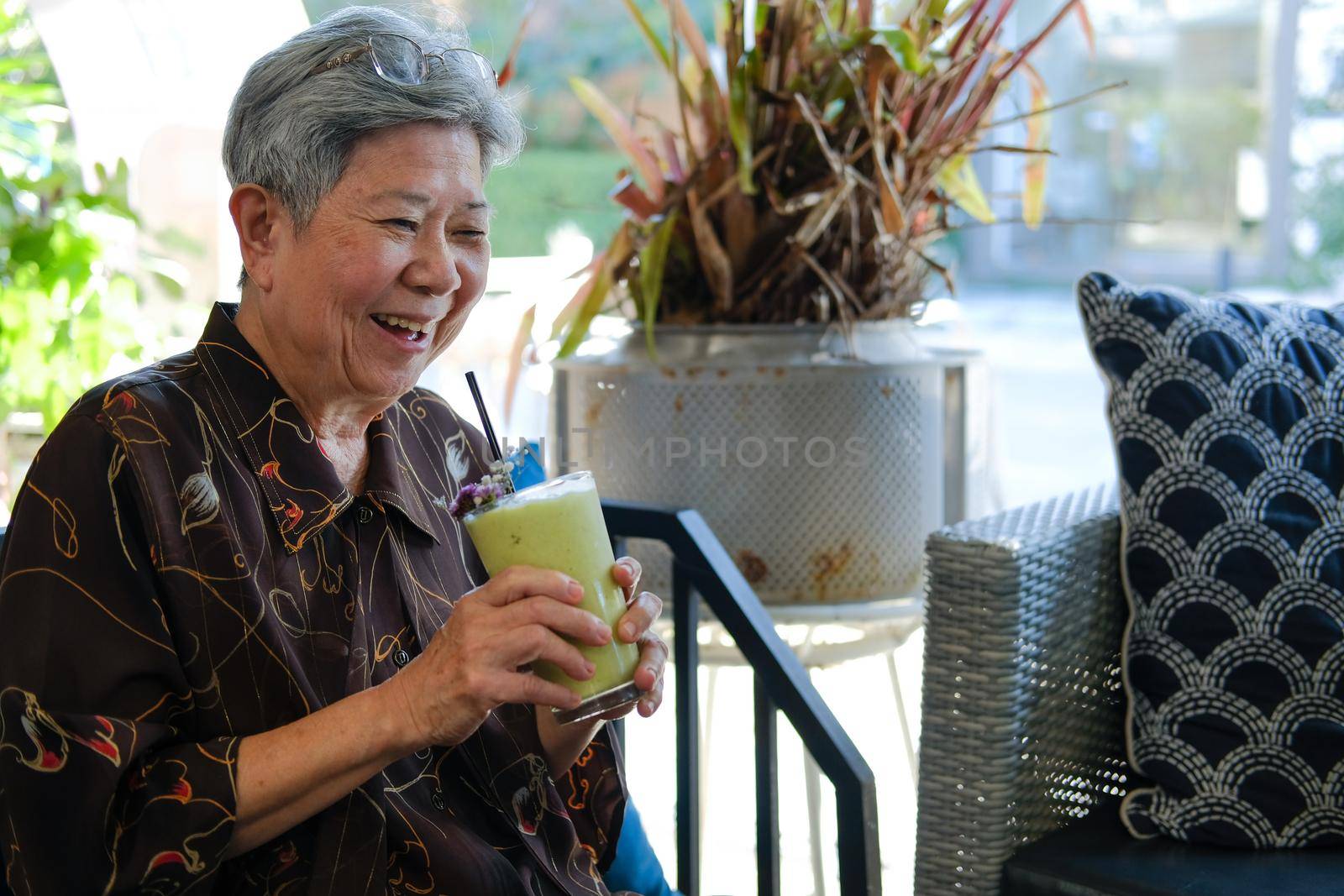old asian elderly senior elder woman drinking avocado smoothie milkshake at restaurant.